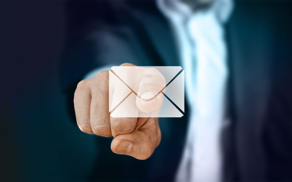 EDV-Leeb Kontaktformular. Ein Mann im Anzug drückt mit dem Zeigefinger auf eine Virtuellen Symbol in Form von einem Briefkuvert. Steht für den E-Mail Kontakt.